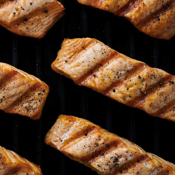 Grilované lososové filety s výraznými mřížkami a kořením – dokonale připravené pomocí CHEF'S COMBI od HOBARTU pro rovnoměrné a profesionální výsledky grilování.