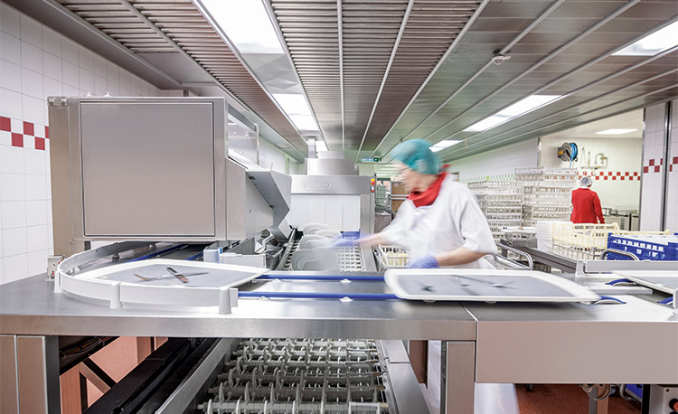 Dopravník FLOW Line autoLINE v mycí kuchyni, automatický mycí systém pro tácy a nádobí, nerezová konstrukce s integrovanou dopravní technologií pro efektivní a hygienické procesy.