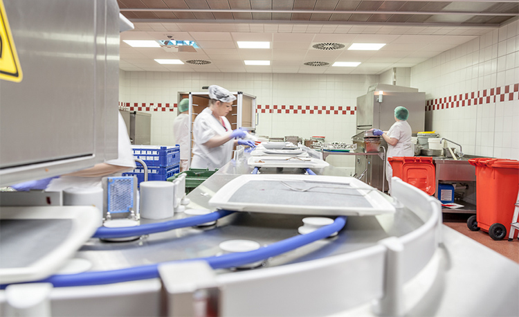 Moderní mycí kuchyně s HOBART FLOW Line autoLINE, automatický mycí systém s dopravníkem a pracovními stanicemi pro efektivní čištění táců, talířů a sklenic, nerezová konstrukce pro hygienické a optimalizované procesy.