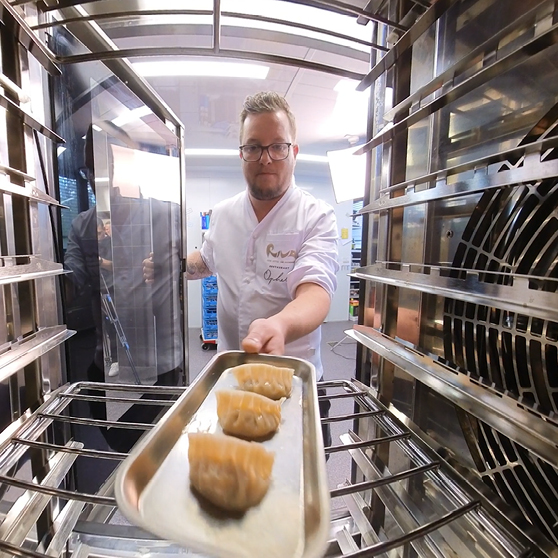 Plechem s připraveným jídlem je zasouván do varné komory HOBART CHEF’S COMBI, snímáno z vnitřního pohledu.